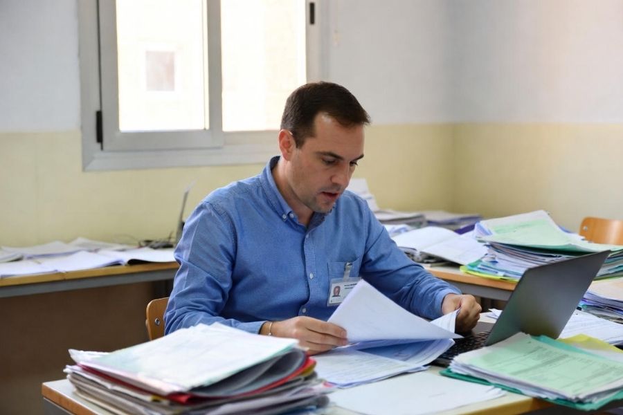 Técnico municipal revisa documentación administrativa y expedientes de contratación menor en un despacho del ayuntamiento.